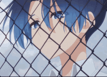 a blue haired anime character is behind a chain link fence