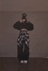 a person wearing a mask and a hat that says supreme is dancing