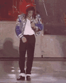 a man in a blue jacket and white shirt is dancing