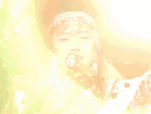 a woman singing into a microphone wearing a headpiece with the letter b on it