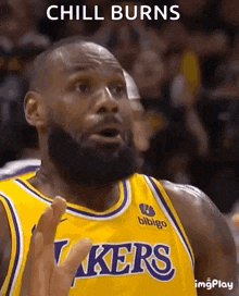 a basketball player with a beard is wearing a lakers jersey and making a funny face .