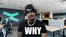 a man wearing headphones and a black shirt with the word why on it