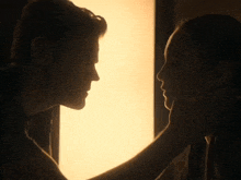 a man and a woman are looking at each other in a dark room