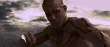 a man without a shirt has a tattoo on his chest that looks like a tree