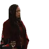 a woman with long dreadlocks is holding a glass and a bottle