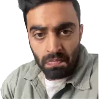 a man with a beard and a green shirt looks at the camera