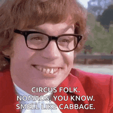 a man wearing glasses and a red jacket is smiling and says circus folk nomads you know smell like cabbage