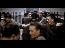a group of people are standing in a room with their arms around each other and one of them is wearing glasses