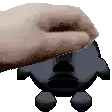 a pixelated image of a hand holding a black object .