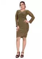a woman in a green dress and black heels stands with her hands on her hips