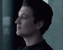 a man in a black suit and tie is smiling .