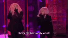 two women singing on a stage with the words that 's all they really want