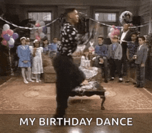 a man is dancing at a birthday party in front of a crowd .