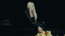a woman sitting on a bench holding an apple in her hand