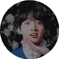 a close up of a person 's face in a circle with flowers behind them