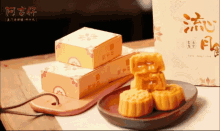 a box with chinese writing on it sits next to a plate of mooncakes
