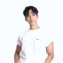 a young man wearing a white t-shirt and jeans is making a gesture with his hands .