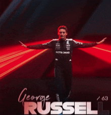a man in a petronas uniform stands with his arms outstretched in front of the name george russell