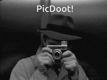a man in a hat is holding a camera in front of his face with the words picdoot below him