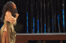 a woman is standing on a stage with blue lights in the background