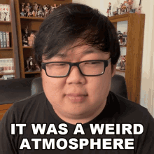 a man wearing glasses has the words it was a weird atmosphere above his head