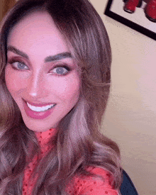 a close up of a woman 's face with a picture on the wall in the background