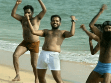 a group of men are dancing on the beach and one of them is wearing a pair of underwear that says calvin klein