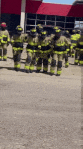 a group of firefighters are standing in front of a building