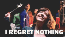 a woman holding a sparkler with the words " i regret nothing " above her