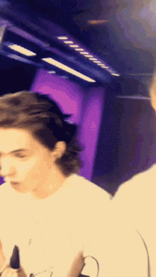 a blurry picture of a person 's face with a purple wall in the background