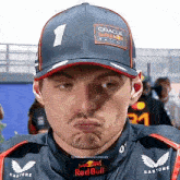 a man wearing a red bull hat makes a face