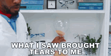 a man in a lab coat is holding a hourglass and says " what i saw brought tears to me "