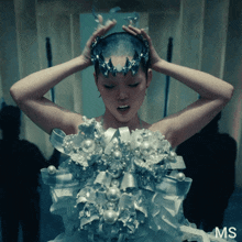 a woman with a crown on her head is wearing a dress that says ms on it