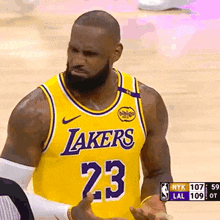 a basketball player wearing a lakers jersey is talking to a referee .