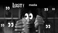 a black and white photo of a man behind bars with cartoon eyes on his face .