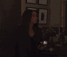 a woman is holding a flashlight in her hand in a dark room