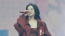 a woman is singing into a microphone on a stage .