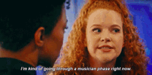 a woman with red hair is talking to a man and says i 'm kind of going through a musician phase right