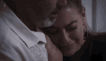 a man and woman are hugging with the number 5 on the bottom