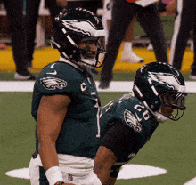 two eagles football players one wearing number 1 and the other wearing number 50
