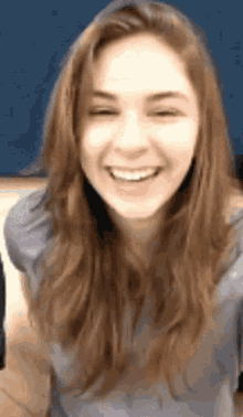 a close up of a woman 's face smiling with her eyes closed