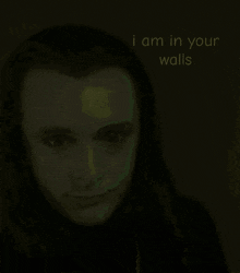 a picture of a man with long hair and the words i am in your walls behind him