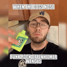 a man wearing glasses and a la hat is holding a bottle of punk rock openhiemer wendys