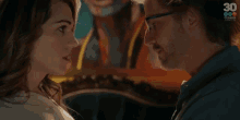 a man and a woman are looking at each other and the woman is saying contestame