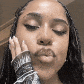 a close up of a woman 's face with her hand on her face .