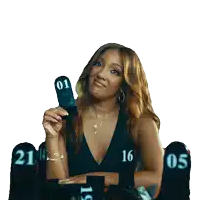 a woman in a black dress holds up a sign with the number 1 on it