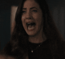 a close up of a woman screaming with her mouth wide open