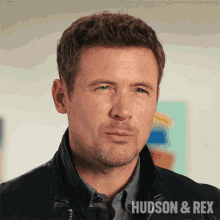 a close up of a man 's face with the words hudson & rex on the bottom right
