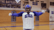 a mascot for the devils stands in front of a banner for the battlefield