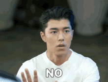 a man in a white shirt says no with his hands outstretched
